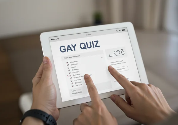 Person interacting with a gay quiz on a tablet screen